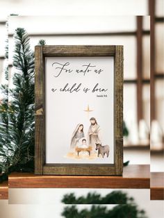 a wooden frame with an image of the birth of jesus on it and a christmas tree