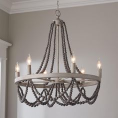 a chandelier hanging from the ceiling with candles in it and beads on the bottom