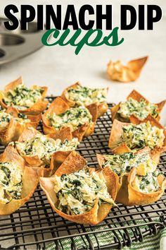 spinach dip cups on a cooling rack with other appetizers in the background