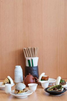 a table topped with plates and bowls filled with different types of food on top of it