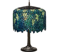 a lamp that is sitting on top of a table with a blue and green shade