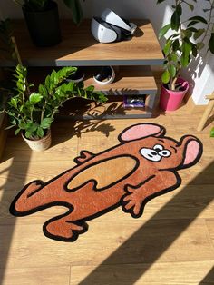 a rug with a cartoon dog on it in the middle of a wooden floor next to potted plants