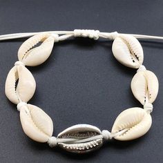 Cowrie Shell Pearl Bead Bracelets for Women    Indulge in this exquisitely crafted Cowrie Shell Pearl Bead Bracelet for Women,  a charming cuff to elevate your style. Feel the luxury of owning this unique piece, designed to add a touch of elegance to any outfit. The cowrie shell pearls gleam with sophistication, making this a must-have accessory for any stylish woman.    Enhance your wardrobe with this exclusive bracelet, perfect for any formal or casual occasion.   Charm Cuff   Gender: Women  M Adjustable Beaded Bangle Jewelry, Adjustable Hand-strung Cuff Bracelet Gift, White Bohemian Jewelry Fashion Accessory, Bohemian Resizable Cuff Bracelet As Gift, Bohemian Resizable Cuff Bracelet Gift, Bohemian Resizable Cuff Bracelet For Gift, Elegant White Bracelets For Vacation, White Spiritual Jewelry For Vacation, White Adjustable Bangle Jewelry