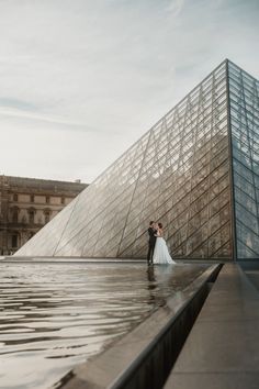 a bride and groom standing in front of the pyramid