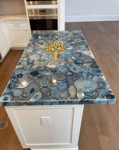 a kitchen island made out of blue and white marble with a tree logo on it