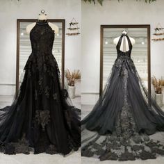 two dresses on display in front of a mirror and one is black with white flowers