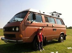 a man standing in front of an old van with a camera mounted on it's roof