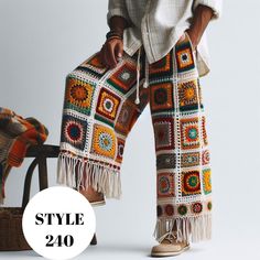 a woman standing next to a chair with a crocheted blanket on it's legs