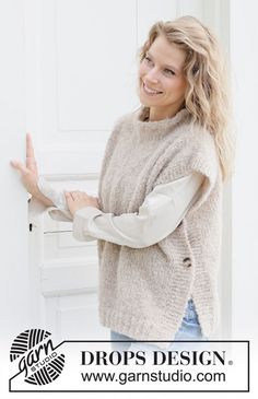 a woman standing in front of a white door with her arms crossed and smiling at the camera