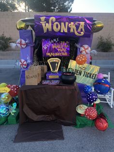 there are balloons and other decorations on the ground near a sign that says wonka