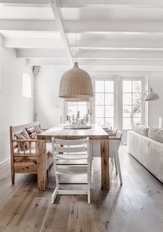 a dining room with white walls and wooden floors