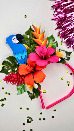 some colorful flowers and streamers on a white surface with confetti scattered around