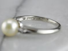 Simple y clásico, este anillo de perlas vintage tiene una banda de oro blanco de 14 quilates bellamente pulida y dos pequeños diamantes decorativos engastados a cada lado de la perla cultivada. La banda tiene un diseño simple y fluido, y la perla blanca cremosa con matices de suero de leche es la pieza discreta perfecta.



 Metal: oro blanco de 14 quilates.

 Gema: Perla

 Medidas de la gema: 6,8 mm, redonda

 Acentos: 2 diamantes con un total de 0,07 quilates

 Tamaño del anillo: 5.50

 Marcas: "14K FANTASY" estampado en la banda interior Vintage Pearl Ring, Pearl Rings Vintage, Fluid Design, Vintage Pearl, White Gold Band, Vintage Pearls, White Gold Ring, June Birth Stone, Ring Ring