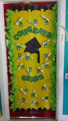 a door decorated with green tissue paper and graduation caps on the front, which reads congrats grads