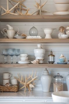 the shelves in this kitchen are filled with dishes and vases, cups, and seashells