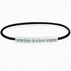 a black leather bracelet with the words swim bike run engraved on it's side