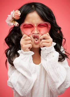 a woman with heart shaped glasses covering her eyes