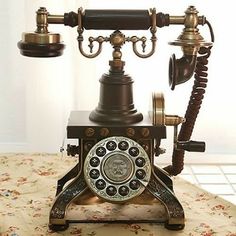 an old fashioned phone sitting on top of a table