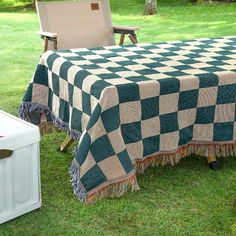 a green and white checkered table cloth sitting on top of a chair in the grass