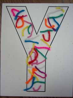 the letter y is made up of colored yarn and plastic straws on a white card