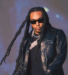 a man with dreadlocks and sunglasses on