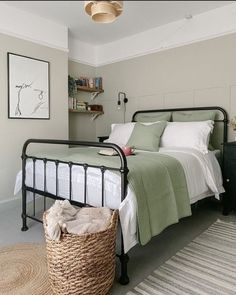 a bedroom with a bed, nightstands and baskets on the floor in front of it