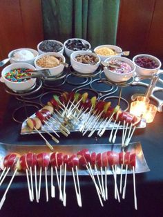 an assortment of food is displayed on a tray with toothpicks and candy sticks