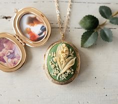 This is a large oval shaped locket necklace in gold finish with a beautifully detailed lily of the valley on a sage green background. This locket is also available in rose gold, bright silver, antiqued silver and antiqued gold finish). The locket measures approx. 1.9'' x 1.4'' (48mm x 35mm) and has beautiful engraving designs on both the front and back. The locket can be opened to hold 2 photos or or hide tiny treasures. How to Send us Photo (s) After your order is submitted, please send us an E Luxury Green Locket Necklaces, Luxury Green Locket Necklace, Green Necklace Locket, Green Lily Of The Valley, Engraving Designs, Sage Green Background, Green Lily, Gold Locket Necklace, Gold Locket