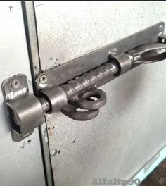 an old metal door handle is attached to the side of a steel door with two handles