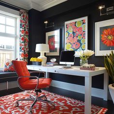 an orange chair sits in front of a white desk with a red rug on it