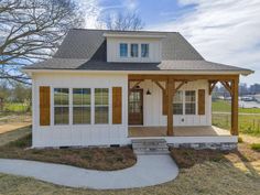 a small white house with wood trim and windows