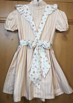 "Dress length (shoulder to bottom hem)27\"/pit to pit 13\"/waist 12 1/2\"/ Apron length (shoulder to bottom hem) 22\"/waist adjustable with sash tie/No pattern supplied/dress is pink green and white striped the apron has a lady bug pattern. The dress is sewn from a 1969 vintage pattern/Please pay attention to measurements size vintage six but please pay attention to measurements/smoke free environment(39)" Cute Fitted A-line Dress, Cute Cotton A-line Sundress, Cute A-line Cotton Sundress, Cute A-line Dress For Dress-up Occasions, Cute A-line Sundress For Garden Party, Cute Summer Vintage Dress With Doll Collar, Short Sleeve Dress With Fitted Bodice For Dress-up, Cute Fitted Ruffled Vintage Dress, Cute A-line Dress For Casual Wear