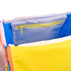 an open yellow and blue bag with zippers