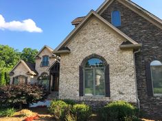 a large brick house with arched windows on the front and side of it's roof