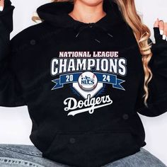 a woman wearing a black hoodie that says national league champs