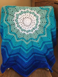 a crocheted blanket sitting on top of a wooden chair