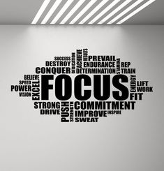 the word focus is written in black on a white wall above an office chair and desk