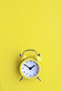 an alarm clock on a bright yellow background