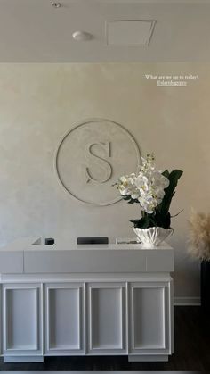 a vase with flowers on top of a white counter