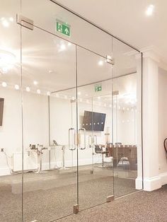 an empty room with glass walls and chairs