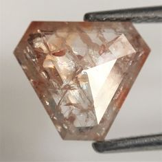 an orange diamond sitting on top of a piece of metal