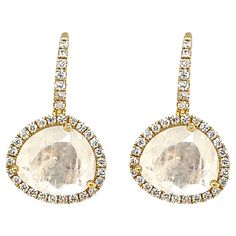 These stylish drop earrings feature pearlescent moonstones surrounded by diamond halos crafted in 18k yellow gold. The moonstones have been faceted - a very unique cutting style for moonstone - allowing them to display beautiful facet reflections in addition to their classic adularescence, or "billowy light effect." Brilliant white diamonds in yellow gold frames outline the moonstones and bring a level of sophistication and elegance to these unusual yet versatile earrings! Moonstones, 10.00 x 9. Gold Frames, Moon Stone, White Diamonds, Round Brilliant Cut Diamond, Halo Diamond, Gold Frame, Diamond White, Moonstone, Halo