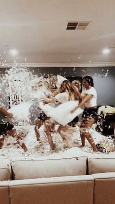 a group of people standing on top of a couch covered in white powder and confetti