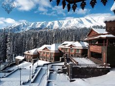 a snow covered ski resort with mountains in the background