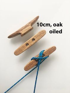 three wooden clothes pins tied together with blue string and wood pegs attached to them