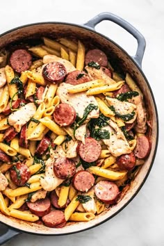 pasta with sausage and spinach in a pan on the counter top, ready to be eaten