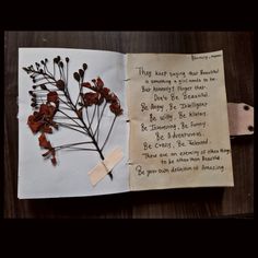 an open book with writing on it and dried flowers in the pages next to it