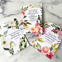 three cards with floral designs on them sitting on a marble surface, one has an envelope and the other has a wedding card