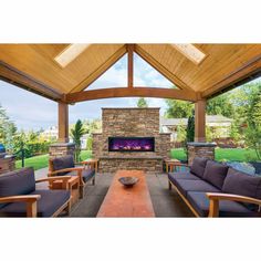 an outdoor living area with couches and a fireplace