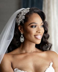 a woman in a wedding dress with a veil on her head and diamond jewelry around her neck